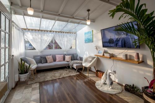 Una sala de estar con un sofá y una ventana. en Departamentos Mi querido Coyoacán, en Ciudad de México