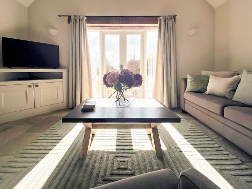 a living room with a couch and a coffee table at The Old Stables 1 in Winterslow