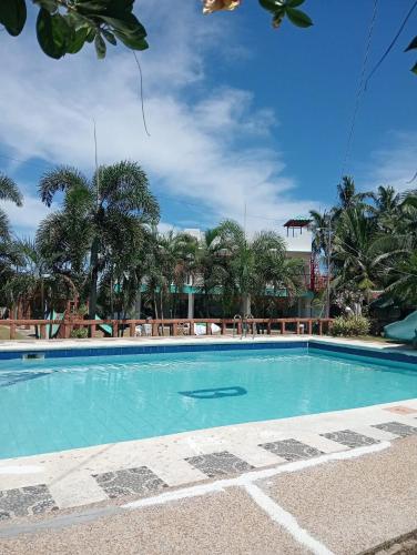 a swimming pool in a resort with palm trees at Bulls residence seaview in Toledo City
