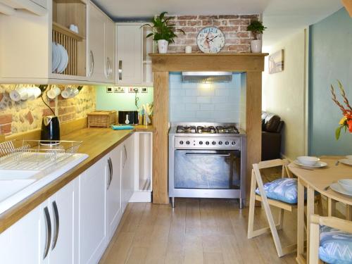 a kitchen with a stove and a counter top at Seashells in Cromer
