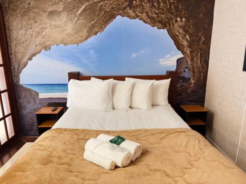 a bedroom with a bed with towels on it at Pousada Ferradura Boutique in Búzios