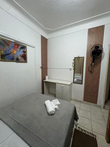 a room with a bed and a mirror in it at Pousada Mãe Linda in Aparecida