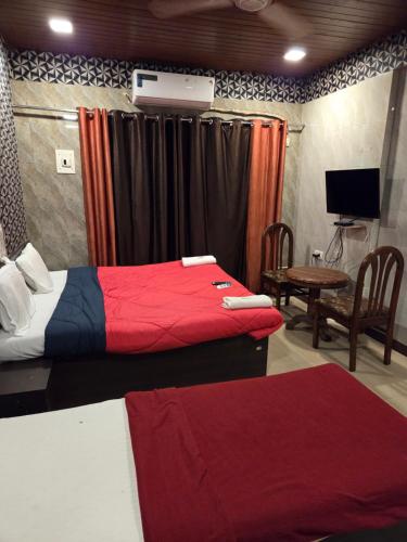 a room with two beds and a television and a table at Hotel Horizon Lonavala in Lonavala