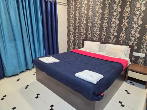 a bedroom with a bed with blue sheets and white pillows at Hotel Horizon Lonavala in Lonavala