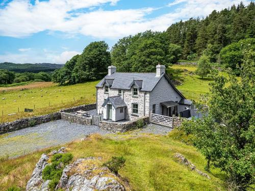 a stone house on a hill in a field at Coed Mawr in Betws-y-coed