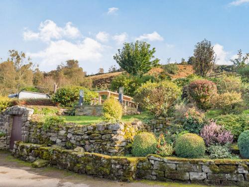 a garden with a stone wall at Buryemwick in Timble