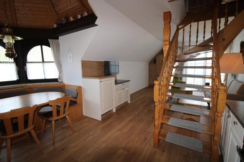 a kitchen and dining room with a staircase in a house at Appartements Panorama Schlössl in Velden am Wörthersee