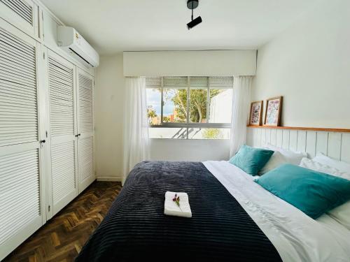 a bedroom with a large bed and a window at Diseño y terraza en Punta del Este in Punta del Este