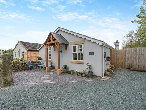 a small white house with a wooden fence at Briar Cottage in Great Eccleston