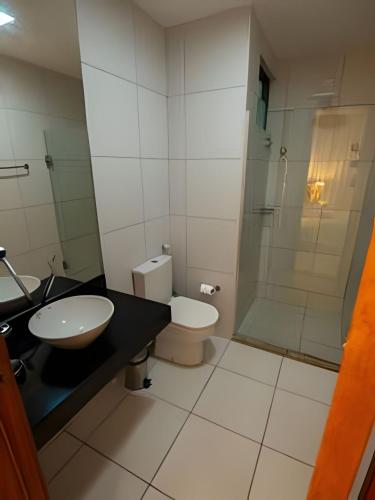 a bathroom with a toilet and a sink and a shower at Iloa Residence 103A in Barra de São Miguel