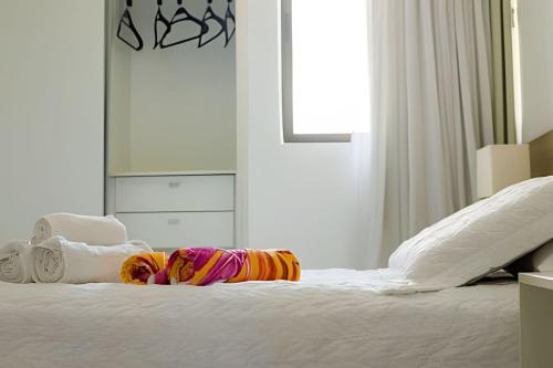 a bedroom with a white bed with white pillows at Iloa Residence 103A in Barra de São Miguel