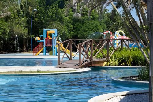 a water park with a bridge over a pool at Iloa Residence 103A in Barra de São Miguel