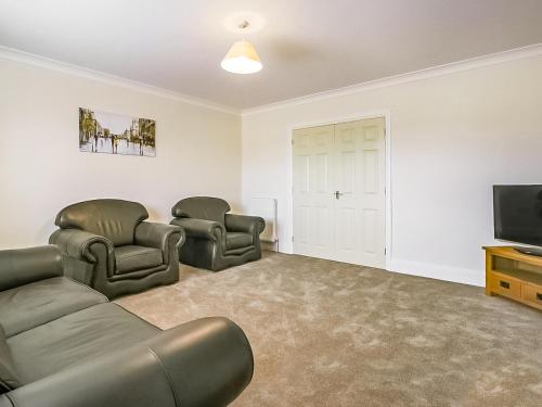 a living room with a couch and two chairs and a television at 4 Dawson Court - Uk33414 in Mablethorpe