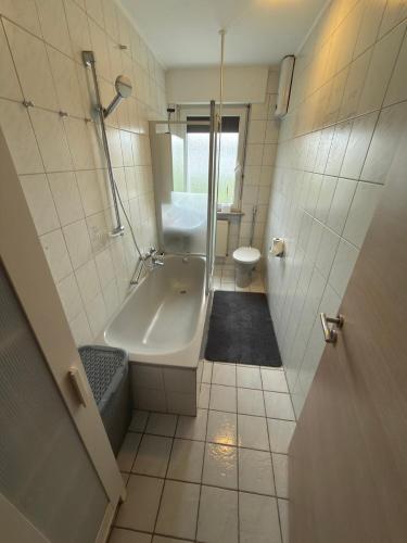 a bathroom with a shower and a tub and a sink at Ferienwohnung Saika in Diefflen