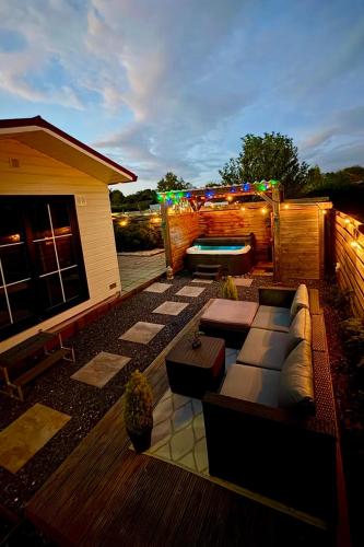a rooftop patio with a couch and a pool at Wellness bungalow with jacuzzi &sauna&private garden near Amsterdam in Vijfhuizen