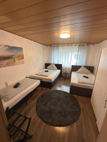 a room with three beds and a rug at Ferienwohnung Saika in Diefflen