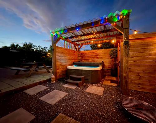 a wooden pergola with a hot tub and lights at Wellness bungalow with jacuzzi &sauna&private garden near Amsterdam in Vijfhuizen