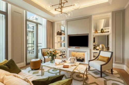 a living room with a fireplace and a television at Corinthia Grand Hotel Astoria Brussels in Brussels