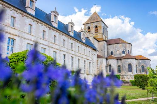 a large building with purple flowers in front of it at Carpe Diem in Saint-Savin-sur-Gartempe