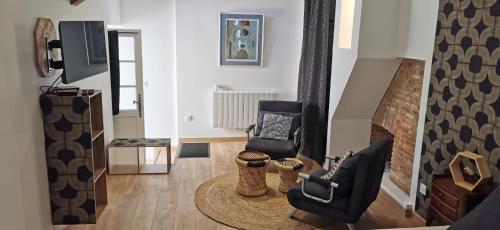 a living room with two chairs and a tv at Carpe Diem in Saint-Savin-sur-Gartempe
