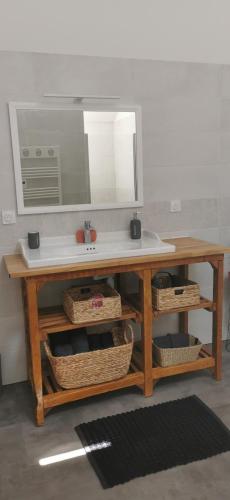 a desk with a mirror and a sink and baskets at Carpe Diem in Saint-Savin