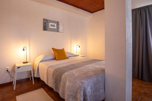 a bedroom with a bed with yellow pillows on it at Casa da Sogra - Apartamento 2 in Faja Grande