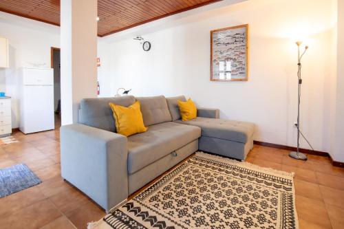 a living room with a blue couch and yellow pillows at Casa da Sogra - Apartamento 2 in Faja Grande