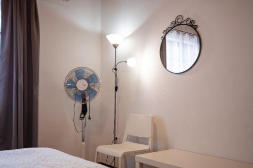 a white bedroom with a fan and a chair at Casa da Sogra - Apartamento 3 in Faja Grande