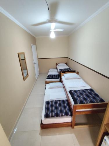 a row of beds in a room with a ceiling at Pousada São Miguel Arcanjo in Aparecida
