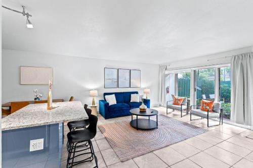 a kitchen and living room with a blue couch at The Olives at Prospect Park in West Palm Beach
