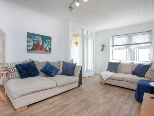 a living room with two couches and a table at Jubilee Cottage in Dawlish