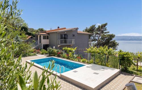 a villa with a swimming pool in front of a house at Stunning Home In Omis in Omiš