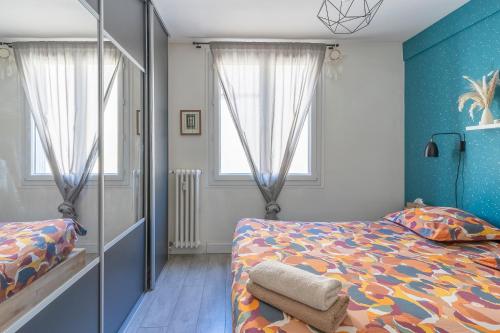 una camera da letto con un letto e due finestre di Boho Zen - T3 calme avec parking en ville a Montpellier