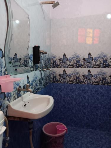 a bathroom with a sink and a blue wall at Mayur Guest House in Pushkar
