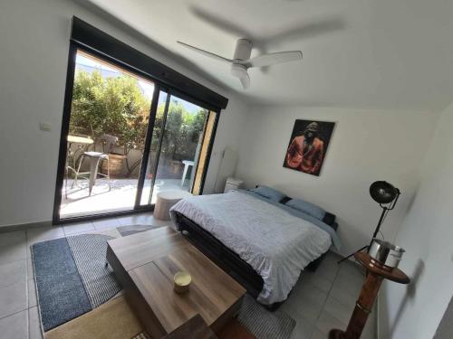 ナルボンヌにあるComfortable ground floor apartment - terrace - parkingのベッドとテーブルと窓のある寝室