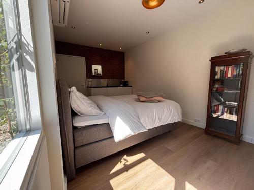 a bedroom with a bed and a book shelf at Guesthouse Mamaloutje in Bemmel