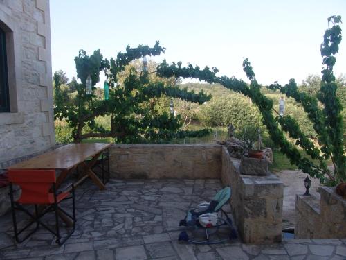 a patio with a wooden table and a bench at Spacious Villa in Margarites with Private Garden in Margarítai