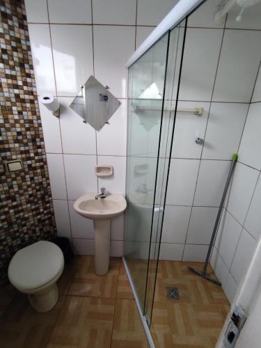 a bathroom with a shower and a toilet and a sink at Pousada São Miguel Arcanjo in Aparecida