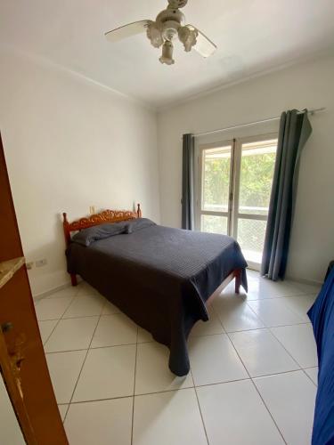 a bedroom with a bed and a window at Casa Verão Guaratuba - Bertioga in Bertioga