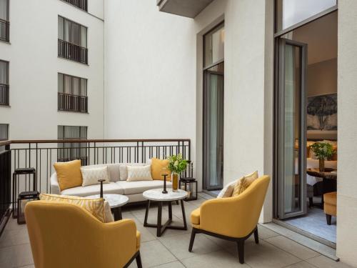 a living room with a couch and chairs on a balcony at Corinthia Grand Hotel Astoria Brussels in Brussels