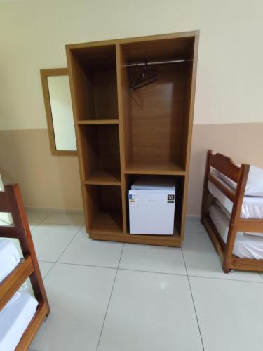 a room with a book shelf with a computer in it at Pousada São Miguel Arcanjo in Aparecida