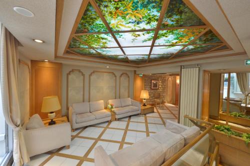 ein Wohnzimmer mit einer Decke und einem Dachfenster in der Unterkunft Hôtel Renoir Montparnasse in Paris