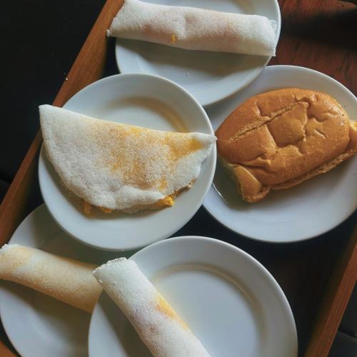 Una bandeja de platos blancos con sándwiches y una hamburguesa. en Jurubeba Hotel de Charme, en Belém