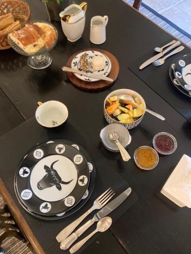 LʼIsle-sur-SereinにあるLa petite Chapelleの黒いテーブル(皿、調理器具付)