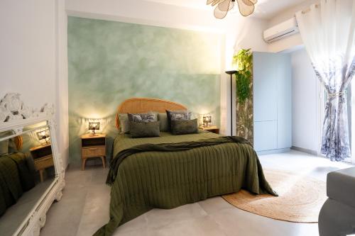 a bedroom with a bed with a green blanket at Casa Vacanze Cormun in Castellammare di Stabia