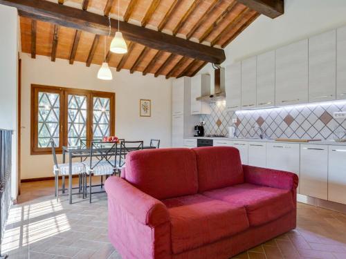 a living room with a red couch in a kitchen at Farmhouse in Tuscany with Pool & Vineyard View in Lucardo