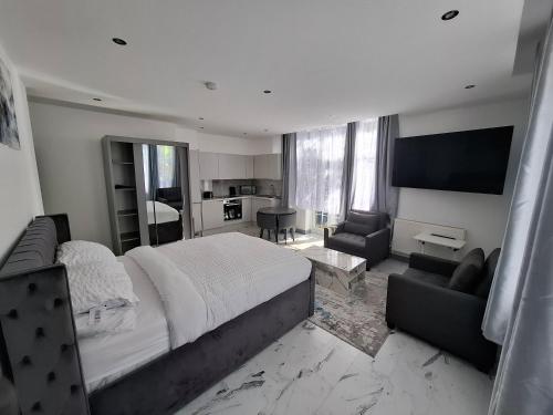 a bedroom with a large bed and a living room at Guyrock Apartments in London