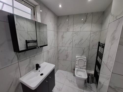 a white bathroom with a sink and a toilet at Guyrock Apartments in London
