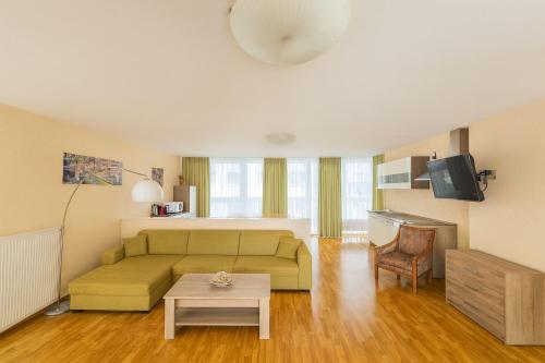 una sala de estar con un sofá y una mesa en Apartments Atomis Hotel Düsseldorf City, en Düsseldorf