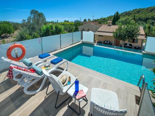 a swimming pool with two chairs and a table next to a pool at Owl Booking Villa Rafale - 5 Min Drive to The Beach in El Port